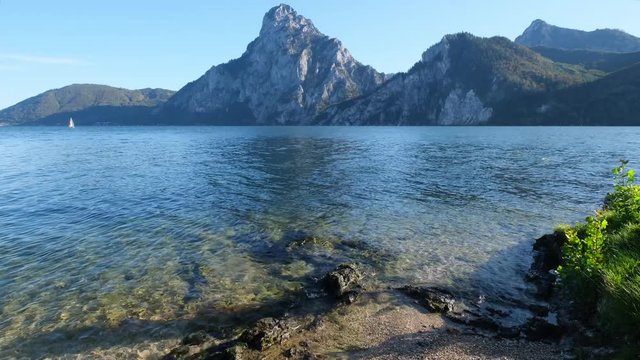 Peaceful autumn morning view to Traunsee lake with unrecognizable seiler and Traunstein mountain in far, Upper Austria.