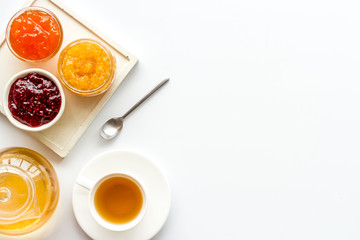 Fruit jam near tea on white kitchen desk frame copy space