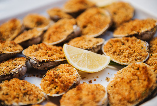 Baked clams with breadcrumbs and lemon garnish