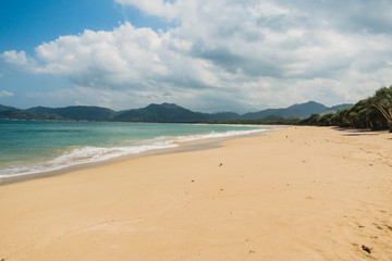 Fototapeta na wymiar Beautiful empty beach on a clear summer day with blue sky and white beach