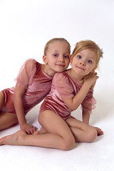 two sisters sitting on a white background