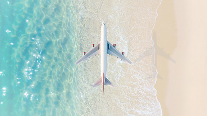 Aerial composite image of airplane flying over turquoise tropical beach, symbolizing vacation travel, summer holidays, and global tourism © AU USAnakul