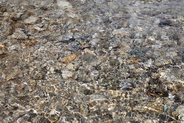 Clean mountain river with a rocky bottom close-up.