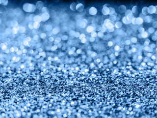 Blue sequin background. Blue sparkle background. Holiday abstract glitter background with blinking lights. 