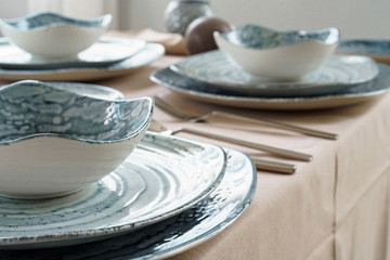 Details of a stylish table setting with textured ceramic dishes