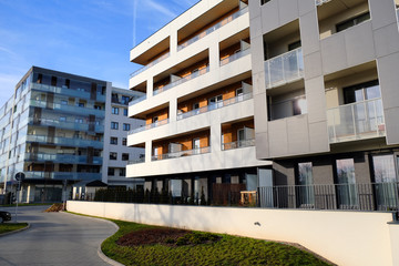 Courtyard with sidewalk and modern apartment building in contemporary residential district.
