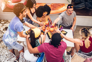 Group of happy multiracial friends having fun drinking and toasting cocktails. Friendship concept with young people having fun togheter at home in the garden