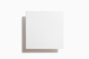 Blank matt paper square catalog magazine in the air isolated on white with soft shadows