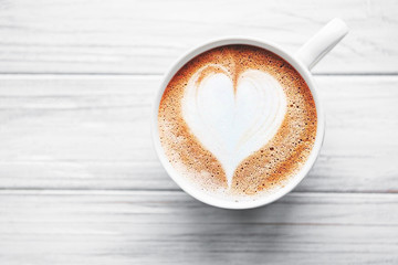 A cup of coffee with heart pattern on a table