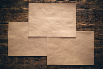 Blank brown paper page on wooden desk flat lay background.