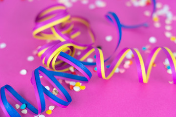 colorful streamers and confetti on pink background