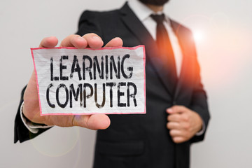 Word writing text Learning Computer. Business photo showcasing learn more about each of the components in the computer Male human wear formal work suit office look hold notepaper sheet use hand