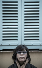 Woman Under a Window with Shutter in Antibes, France.