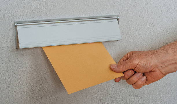 Mann wirft Brief in Briefeinwurf