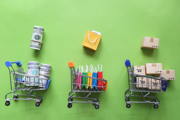 Shopping online, Paper shopping bag and banknote, brown parcel box on model miniature cart on colorful background © Monthira