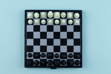 Chess on a blue background. Portable magnetic chess.