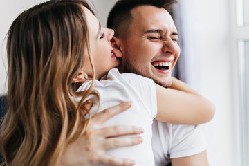 Dark-haired enthusiastic woman fooling around with husband. Funny lady enjoying weekend with...