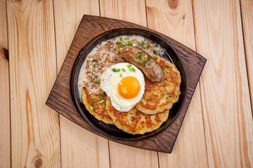 potato latkes with fried egg and sausage, top view