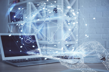 Computer on desktop with social network hologram. Multi exposure. Concept of international people connections.