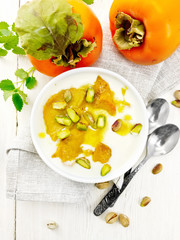 Dessert of yogurt and persimmon in bowl on board top