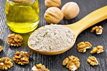 Flour walnut in spoon with oil on dark board