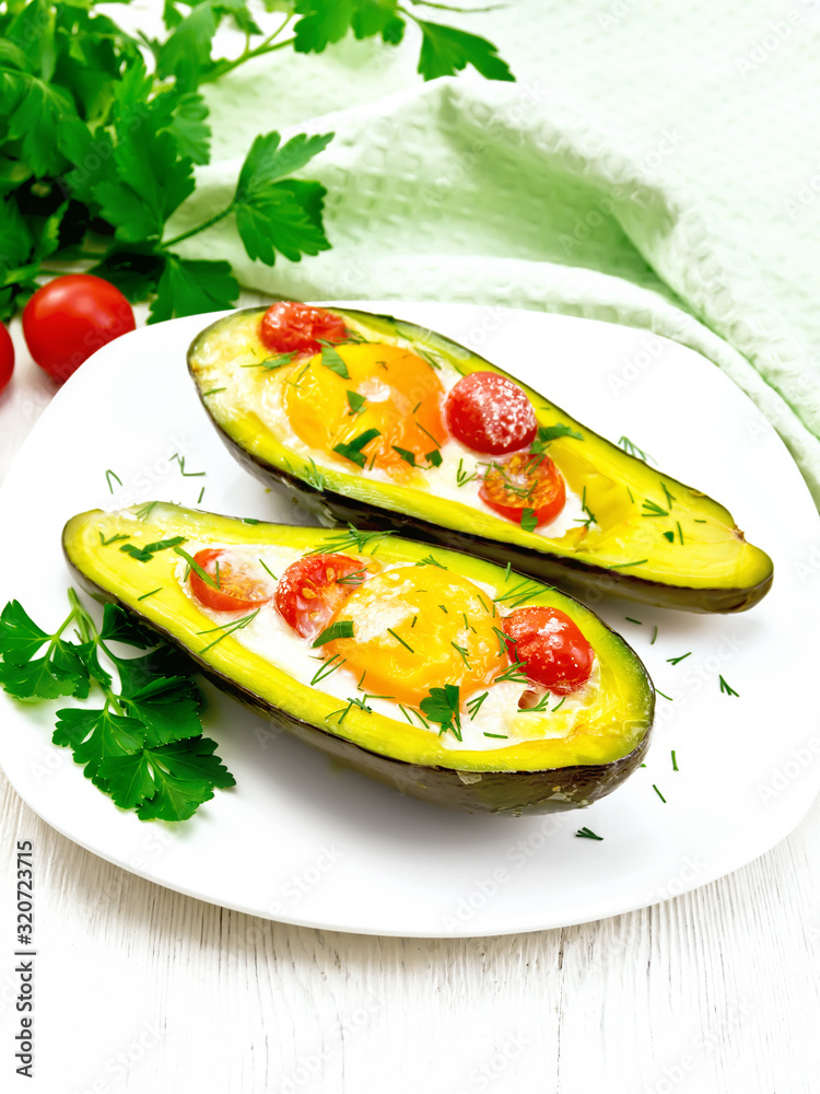 Poster Scrambled eggs with tomatoes in avocado on light table