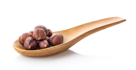 hazelnuts in wood spoon on white background