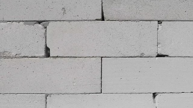 background texture white wall of concrete blocks, filmed during the construction of a new house, large plan, the camera smoothly and steadily moves from left to right