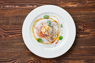 Pancakes with ice cream, whipped cream and maple syrup