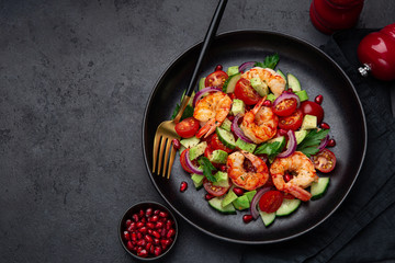 grilled shrimps and vegetable  salad on black plate