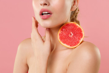 Close up shot cropped blonde half naked woman 20s perfect skin nude make up hold in hand grapefruit...