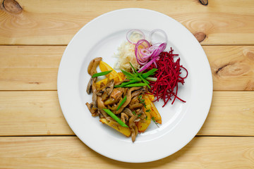 Top view of plate with fried potato, beetroot, pickled cabbage and mushrooms