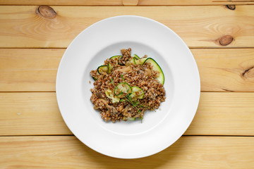 Overhead view of boiled  buckwheat with marinated mushrooms and fresh cucumber