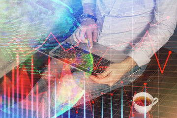 Forex graph with businessman working on computer in office on background. Concept of analysis. Double exposure.