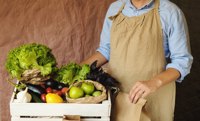 Organic vegetables and fruit in market. Man seller with eco bag and products in organic food store.  Healthy nutrition, eating, Zero Waste, Lifestyle Concept. Banner for for web, design. Close up