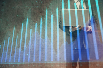 Forex graph with businessman working on laptop on background. Concept of hardworking. Multi...