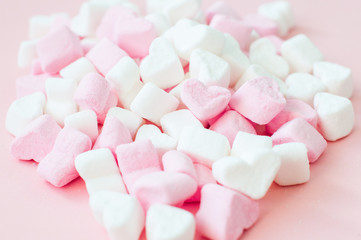 Pink fluffy heart shaped marshmallows candy background.