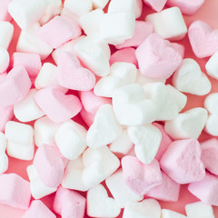 Pink fluffy heart shaped marshmallows candy background.