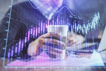 Forex graph with businessman working on computer in office on background. Concept of hardworking....