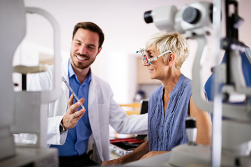 Naklejka na ściany i meble Senior woman taking an eyesight test examination at an optician clinic