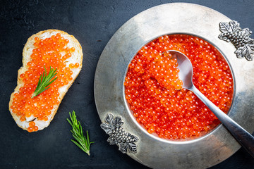 Delicious red caviar in vintage plate, top view, dark background