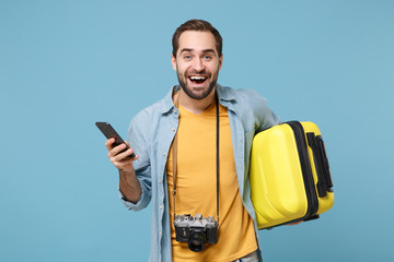 Cheerful traveler tourist man in summer clothes with photo camera isolated on blue background. Male...