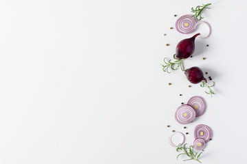 Creative composition with slices of red onion, spices and herbs on white background top view.