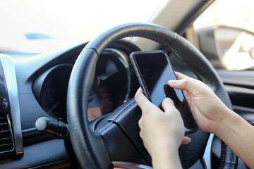 Naklejka premium women using smart phone mobile phone in car while driving.