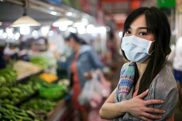  Beautiful asia woman wearing mouth mask against air smog pollution PM 2.5 and Coronavirus in the community,bangkok thailand.