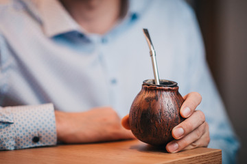 A man in a bar with calabash mate - a traditional tonic drink
