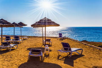 Sun loungers on sand beach