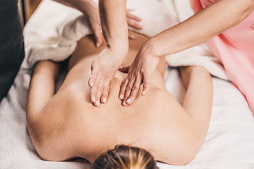 Fototapeta na wymiar Massage in the area of the scapula female masseur - back massage