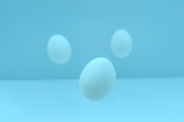 Flying easter eggs on light background.