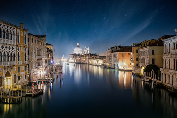 Blick über den Canal Grande von Venedig auf die beleuchtete Skyline bei Nacht mit Sternenhimmel, Italien